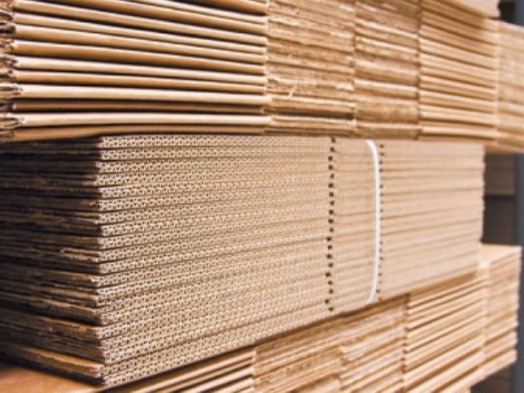 Planchas de cartón corrugado apiladas en la fábrica